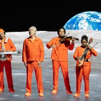 David Byrne takes Miller High Life Theatre to moon, visits Bobblehead Hall Of Fame
