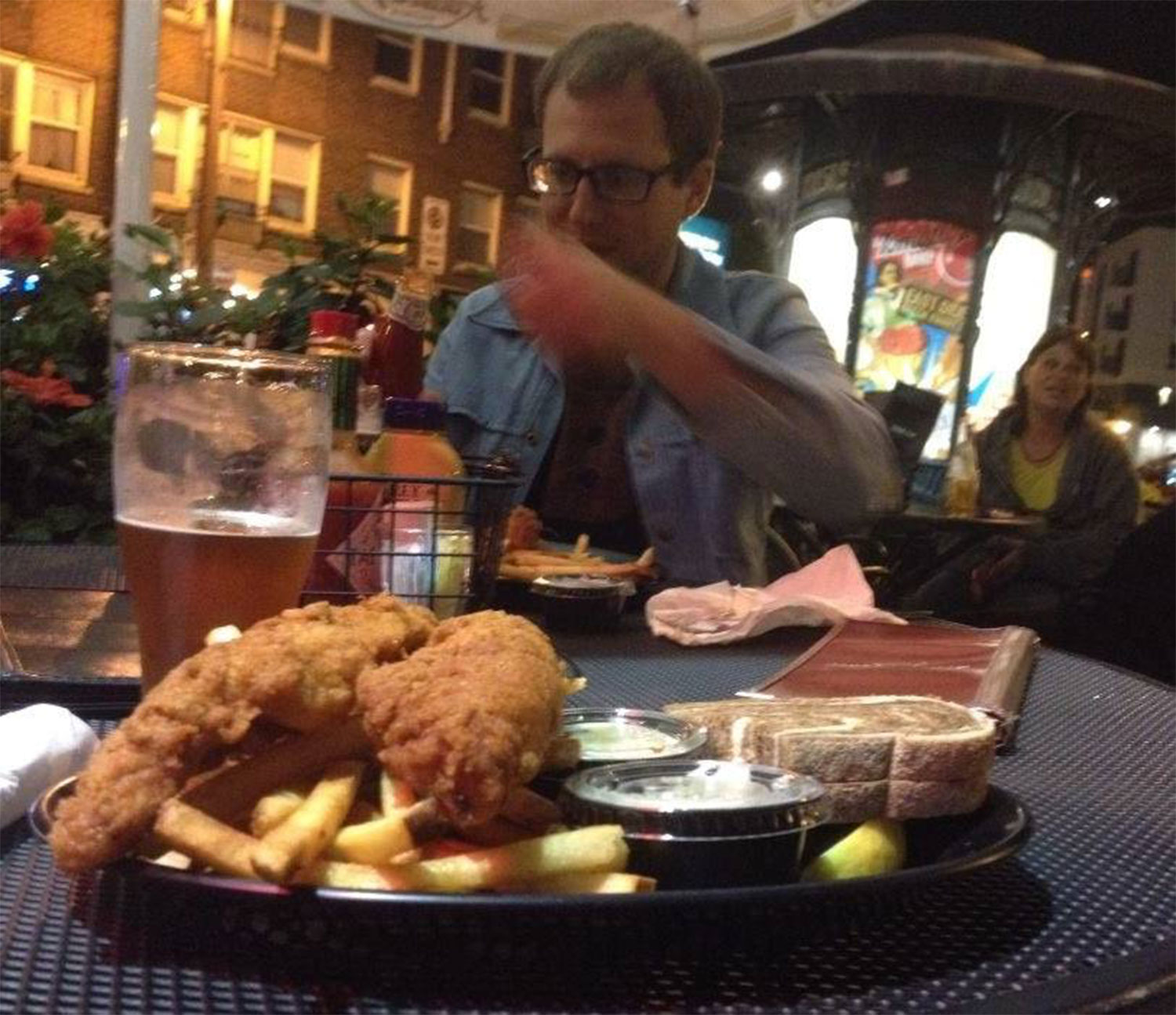Caleb eating a fish fry outside Hooligan's in 2014